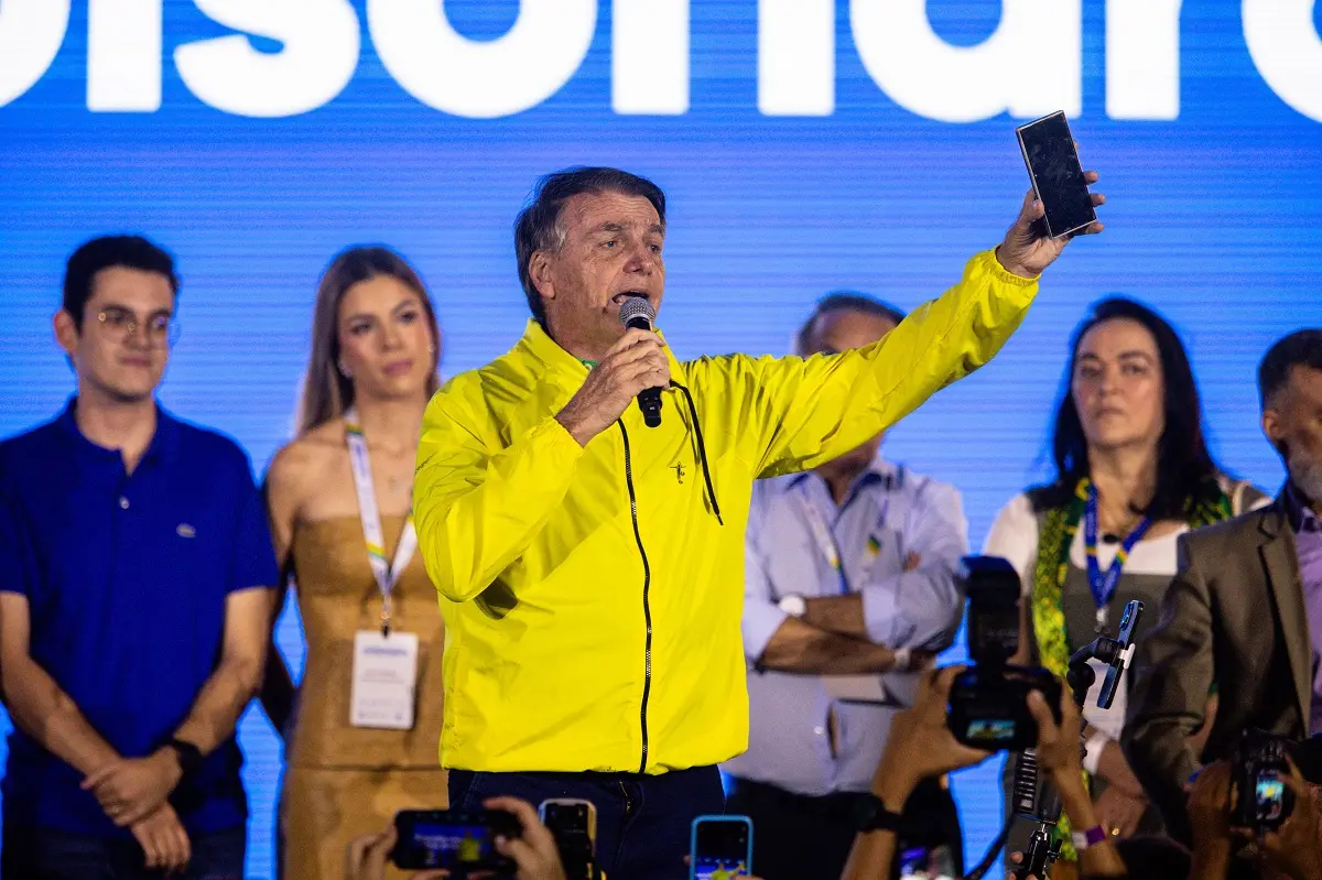 Jair Bolsonaro levantando celular durante discurso no 2º Seminário de Comunicação do PL