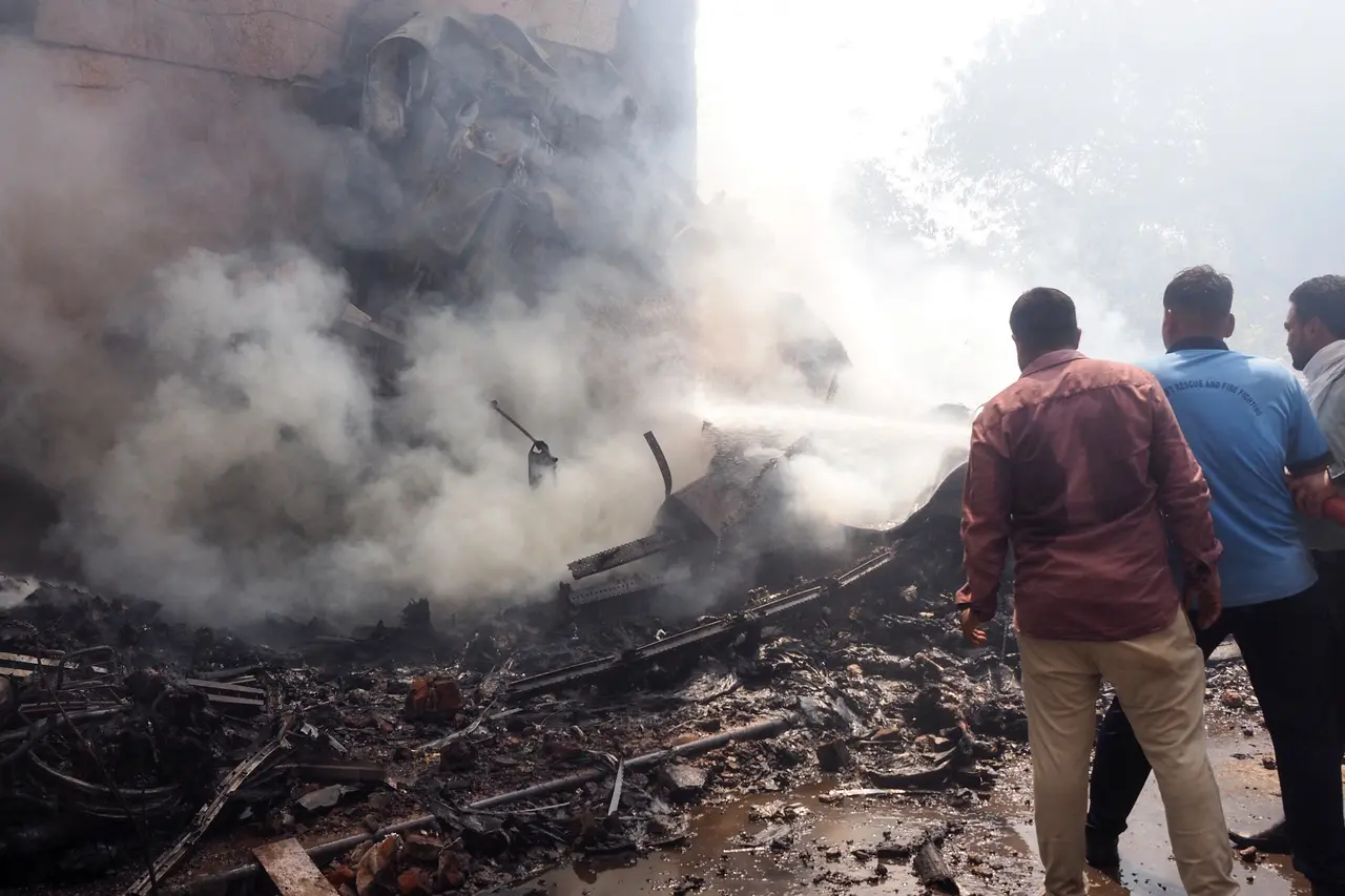 Pessoas observam destroços de Avião que caiu na Índia com 242 pessoas a bordo