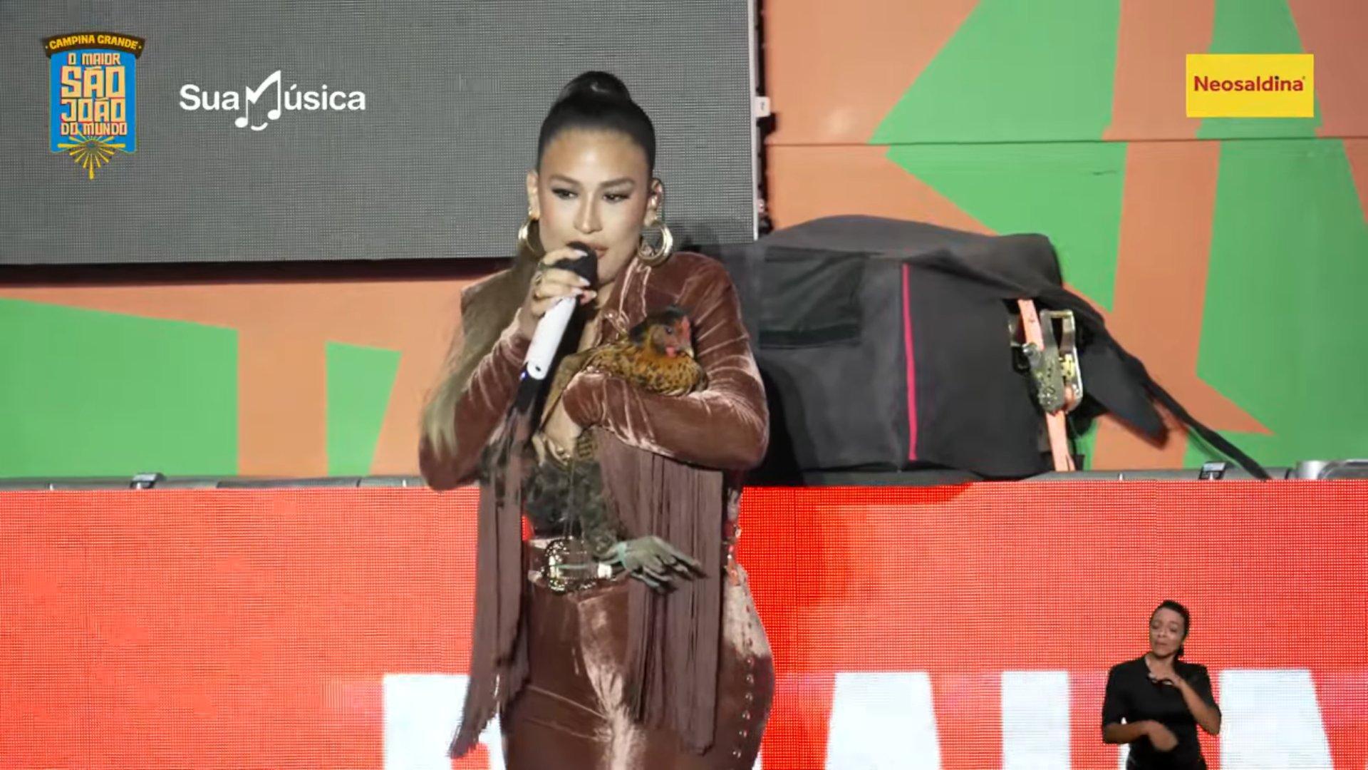 Simone mendes abraçando galinha que recebeu de presente durante show em Campina Grande