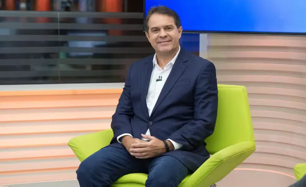 Evandro Leitão em entrevista de televisão sentado em cadeira verde, vestindo terno azul e camisa branca, com cenário de estúdio ao fundo, otimizado para palavras-chave relacionadas a entrevistas na televisão.