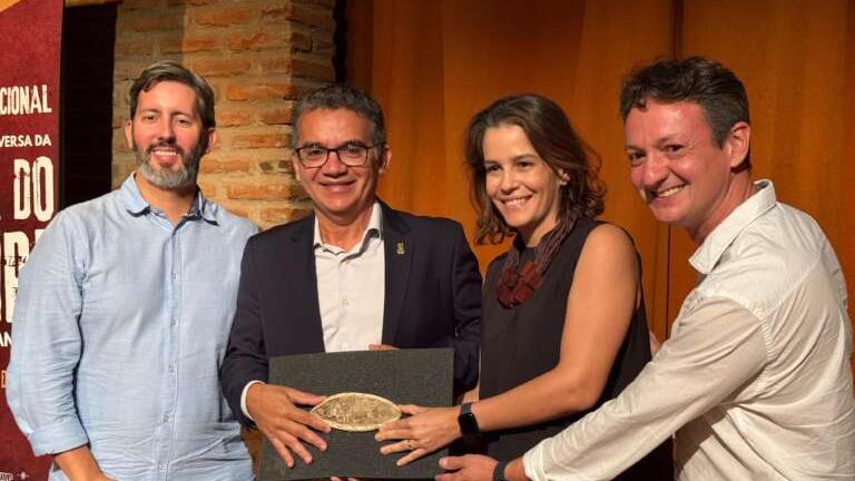 Membros da comitiva segurando um dos fósseis que retornará ao Brasil