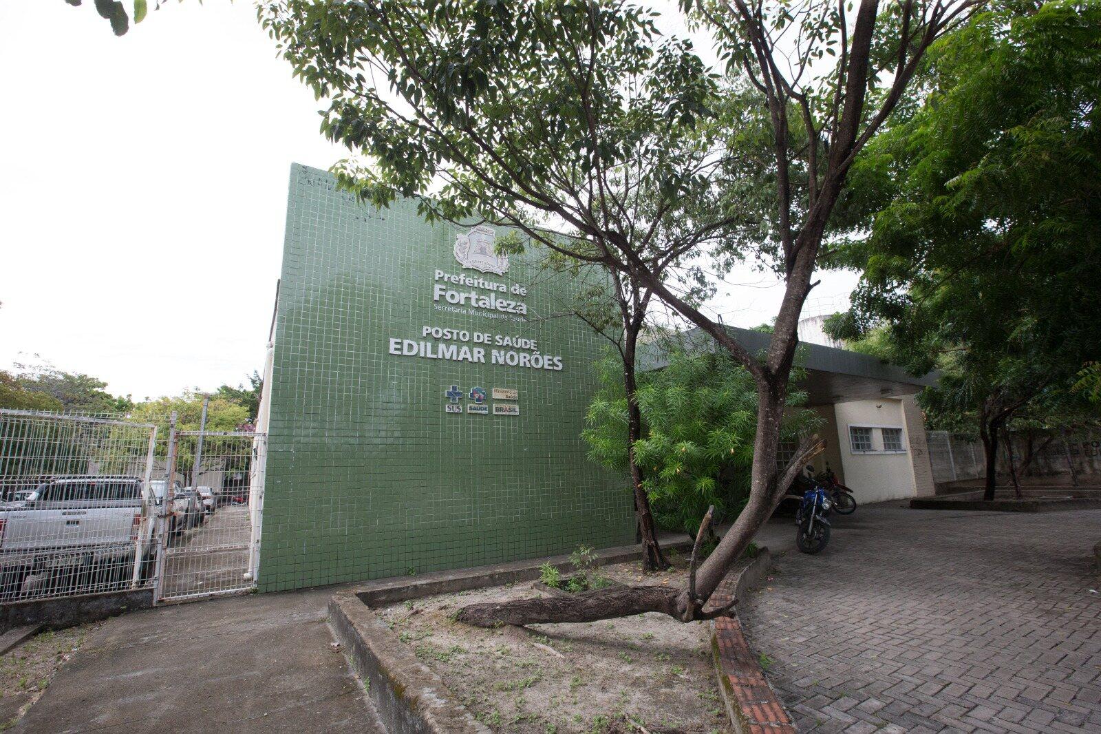 Imagem mostra fachada verde do posto de saúde Edilmar Norões, no bairro Parque Dois Irmãos, com uma grande árvore na frente