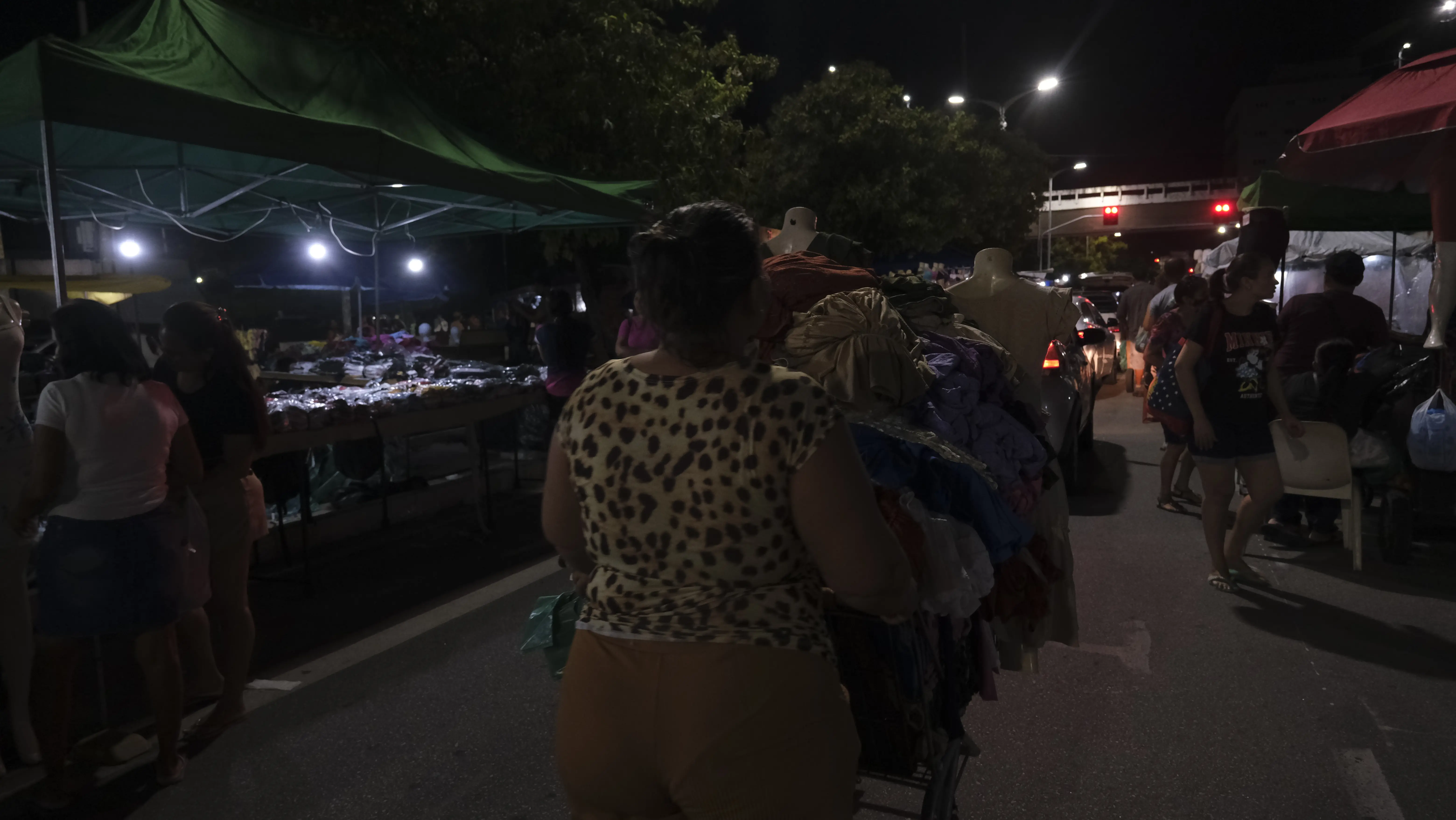 Comerciante anda com roupas na rua durante Feira da Madrugada