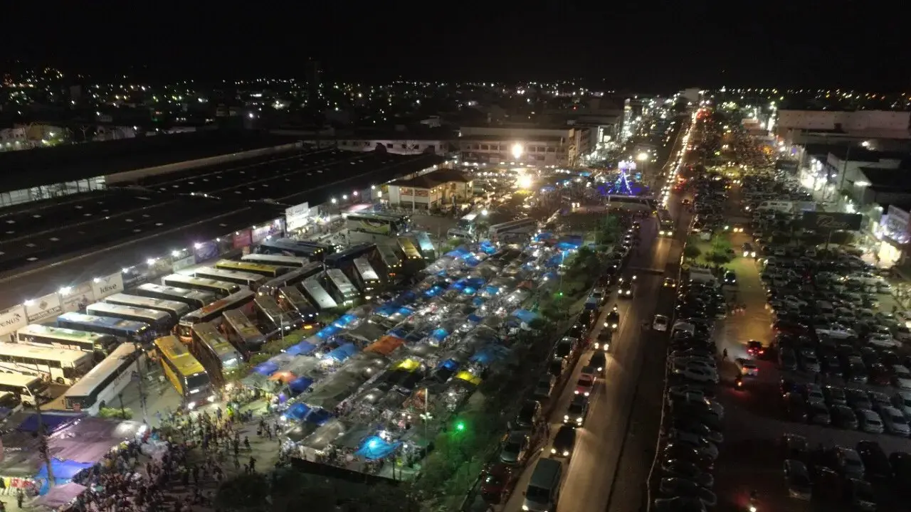 Foto aérea que contém a Feira do Jeans de Toritama, com galpões, ônibus e veículos diversos abaixo