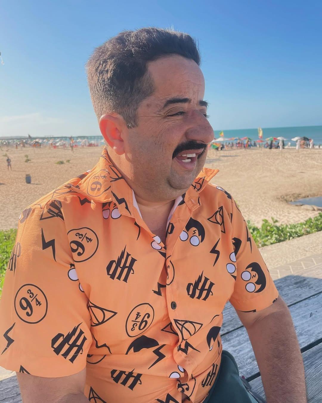 Imagem mostra humorista cearense Paulo Sergio Miranda de Barros, mais conhecidos como Bolachinha, com paisagem praiana ao fundo, ilustrando atualização do estado de saúde dele após sofrer acidente e fraturar perna em gravação