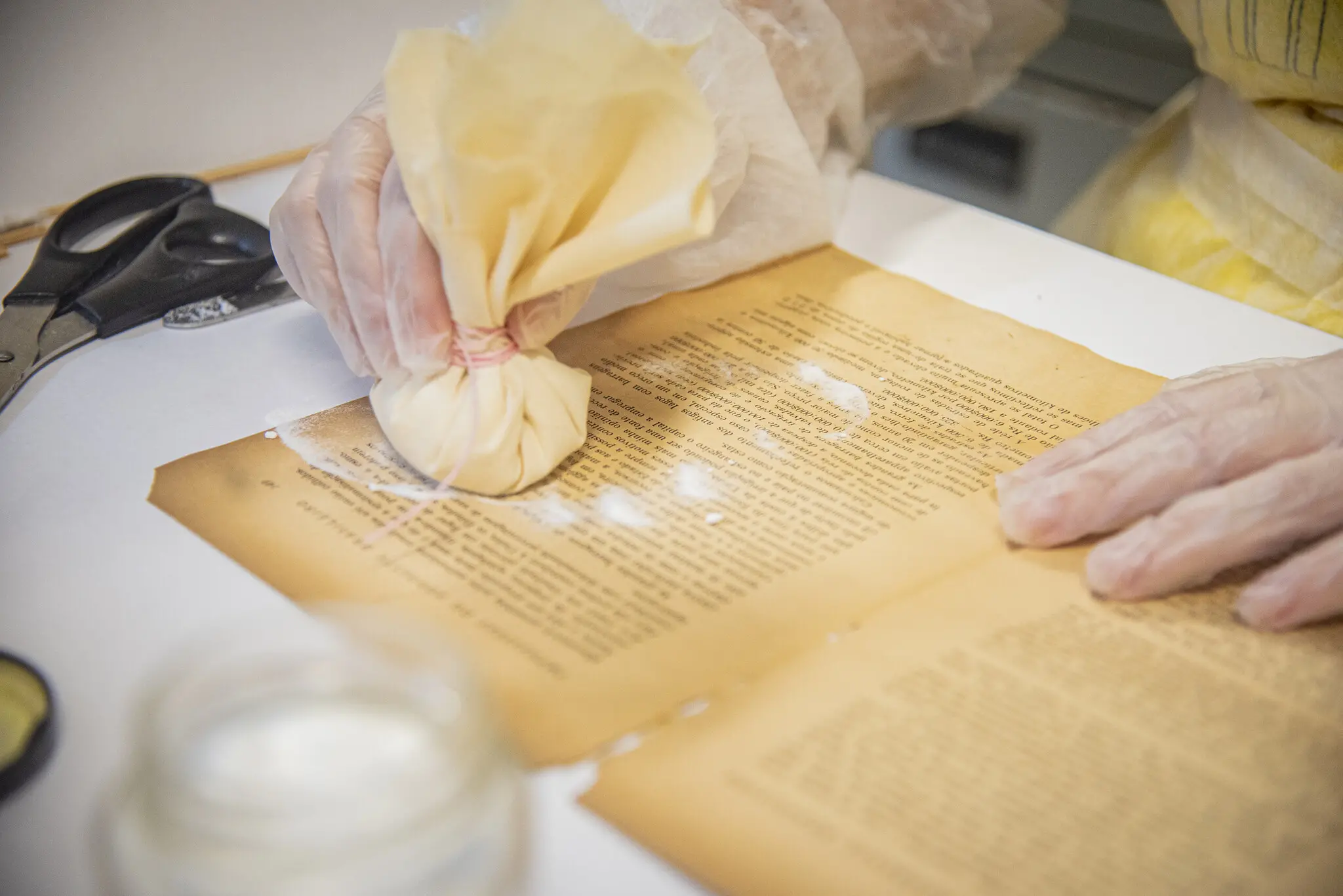 Aluno aplica técnica de conservação em página de livro raro