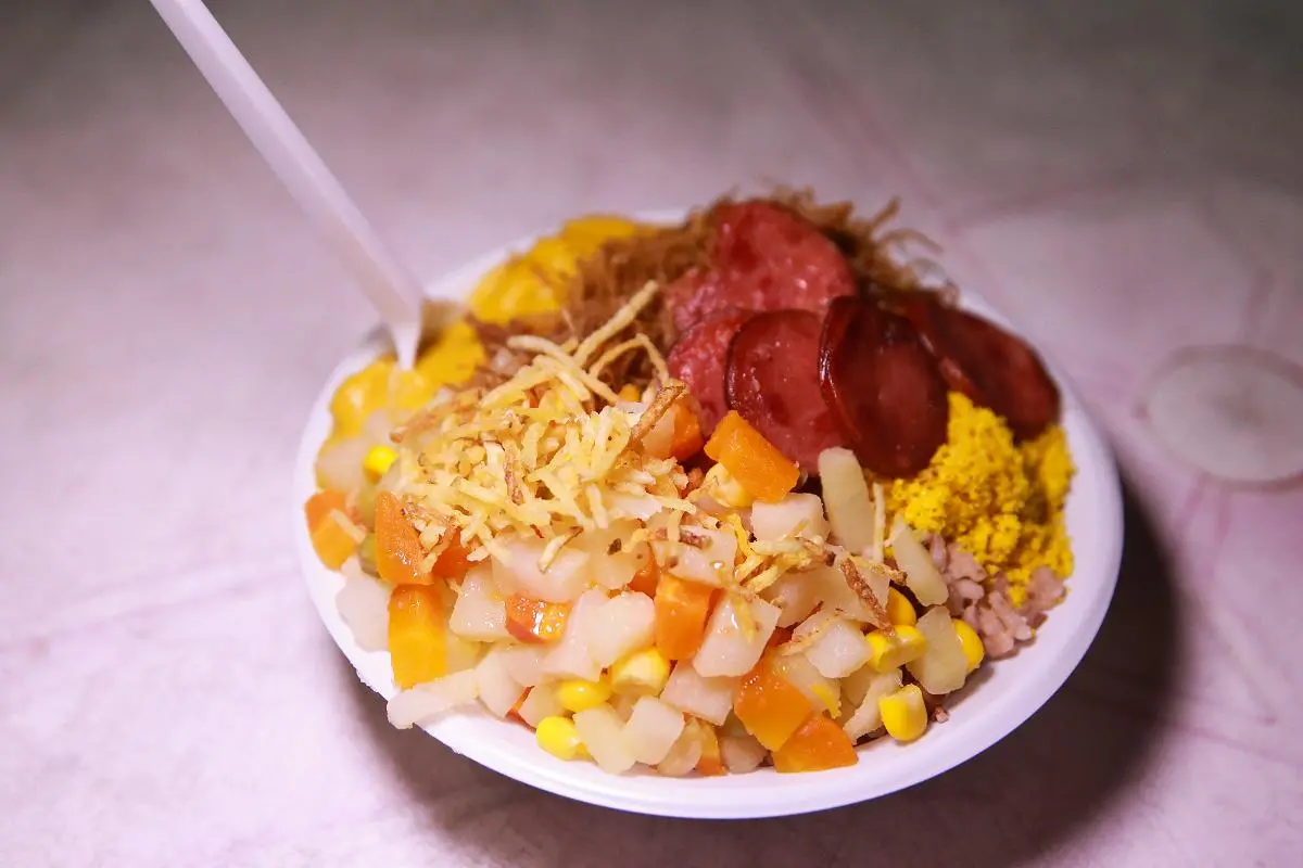 foto de um pratinho, comida típica cearense com baião, verdura, farofa e linguiça calabresa