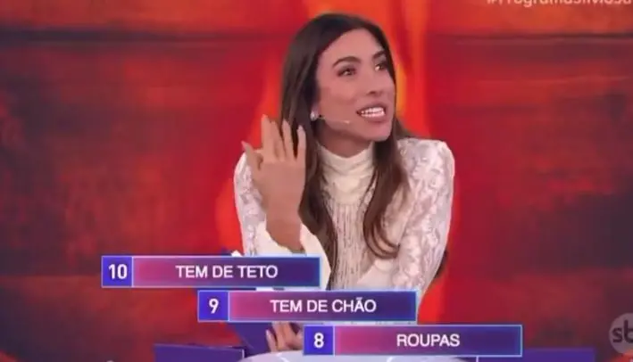 patricia abravanel durante o programa de TV, com as opções sobre a palavra espelho aparecendo na tela. ela está gesticulando.