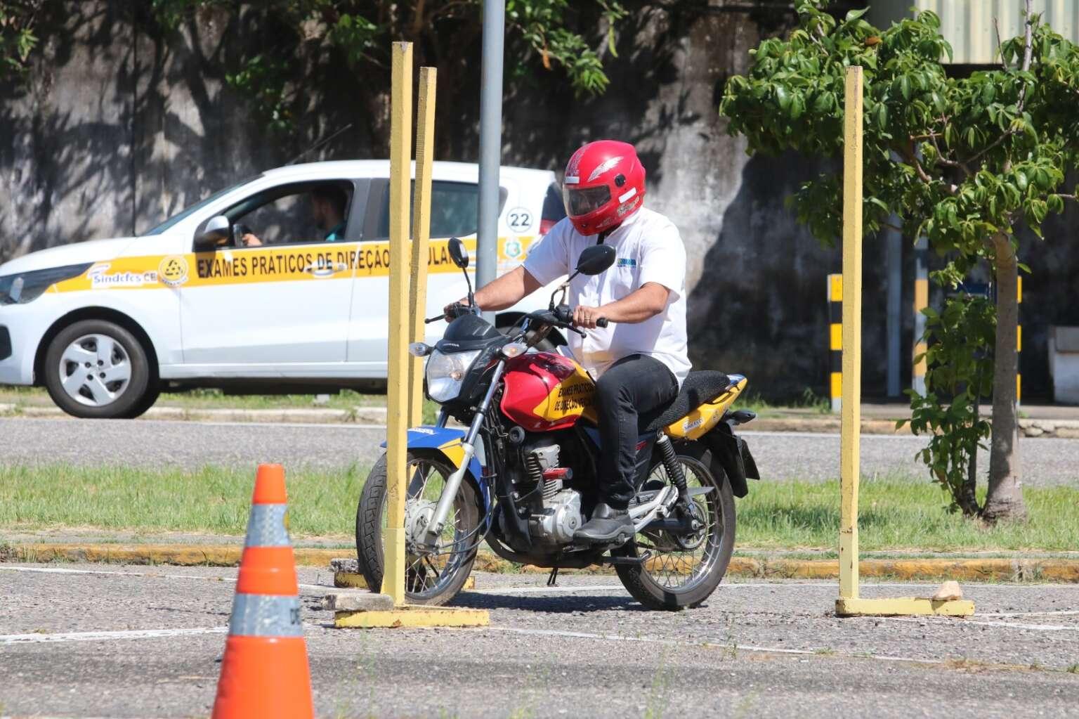 Homem realiza exame prático de direção em motocicleta, em local de prova com cones de trânsito; cearenses não alfabetizados terão oportunidade de estudar e tirar a CNH de forma gratuita.