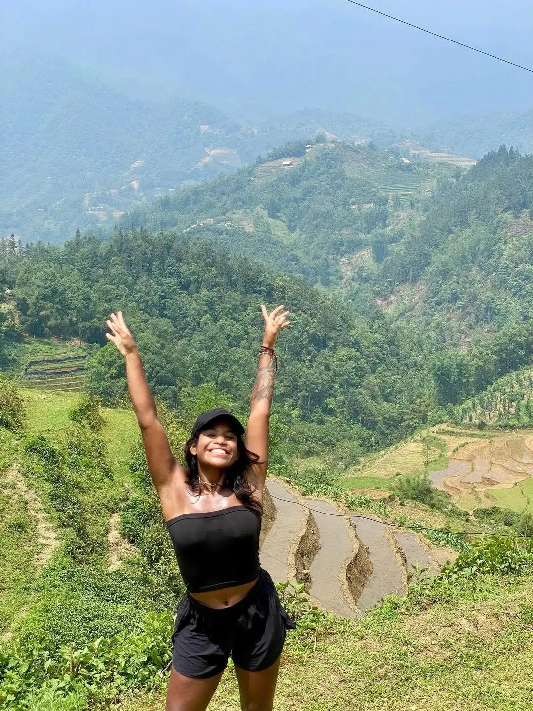 Juliana posa para foto na Indonésia com os braços para o alto. Imagem usada para matéria sobre morte da brasileira