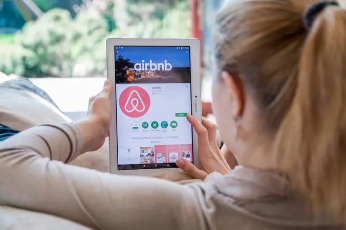 imagem que mostra uma mulher acessando site do airbnb no tablet