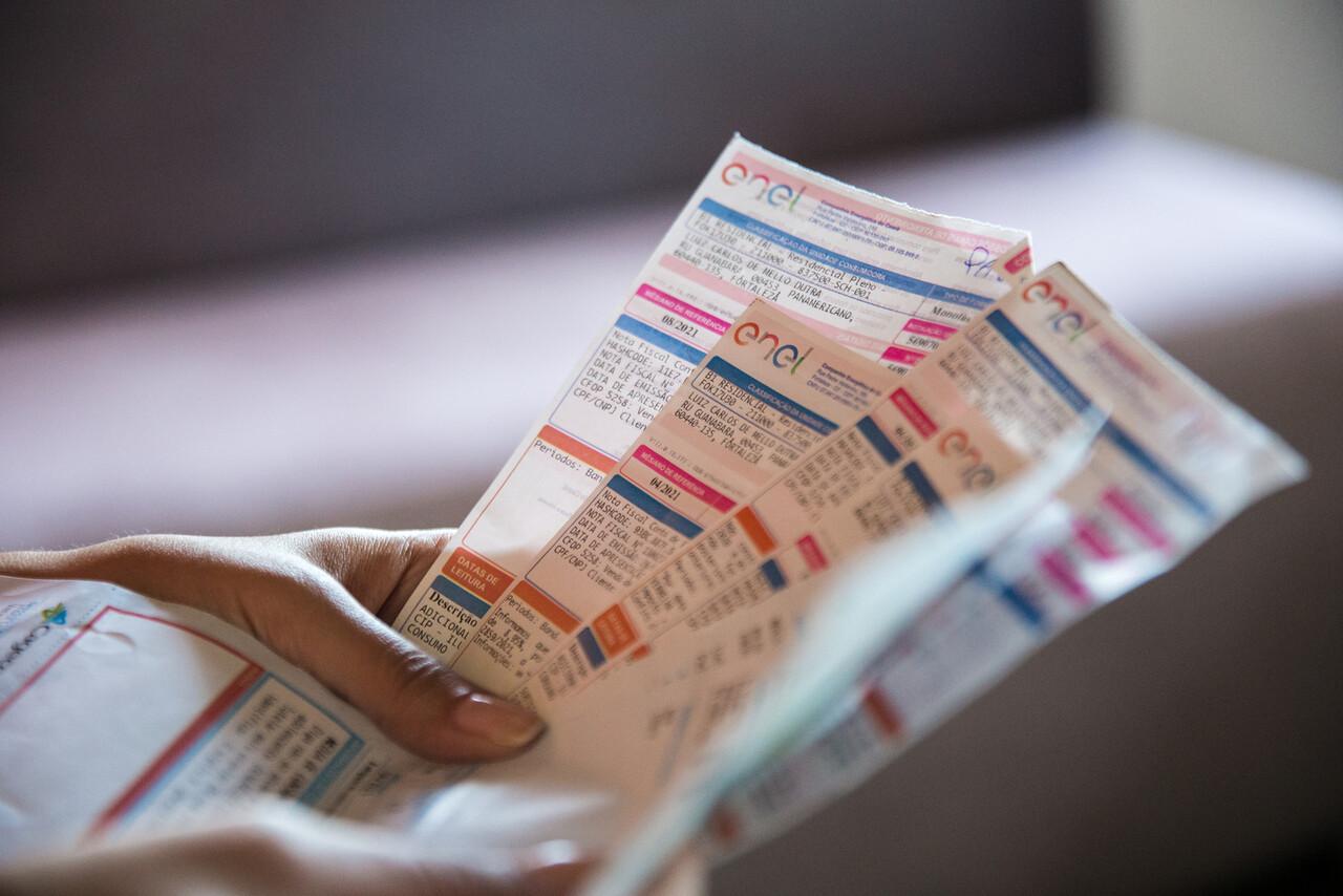 Imagem de consumidor cearense segurando conta de energia elétrica