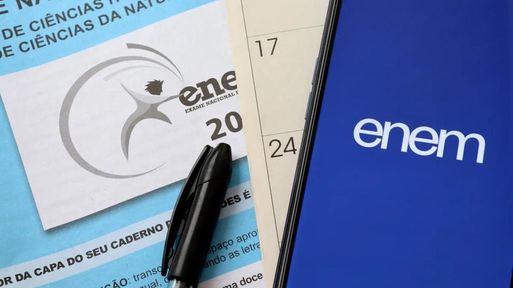 Caderno de provas do Enem ao lado de calendário e celular com logo do exame; prazo para pagamento da taxa de inscrição do Enem 2025 termina em 27 de junho.