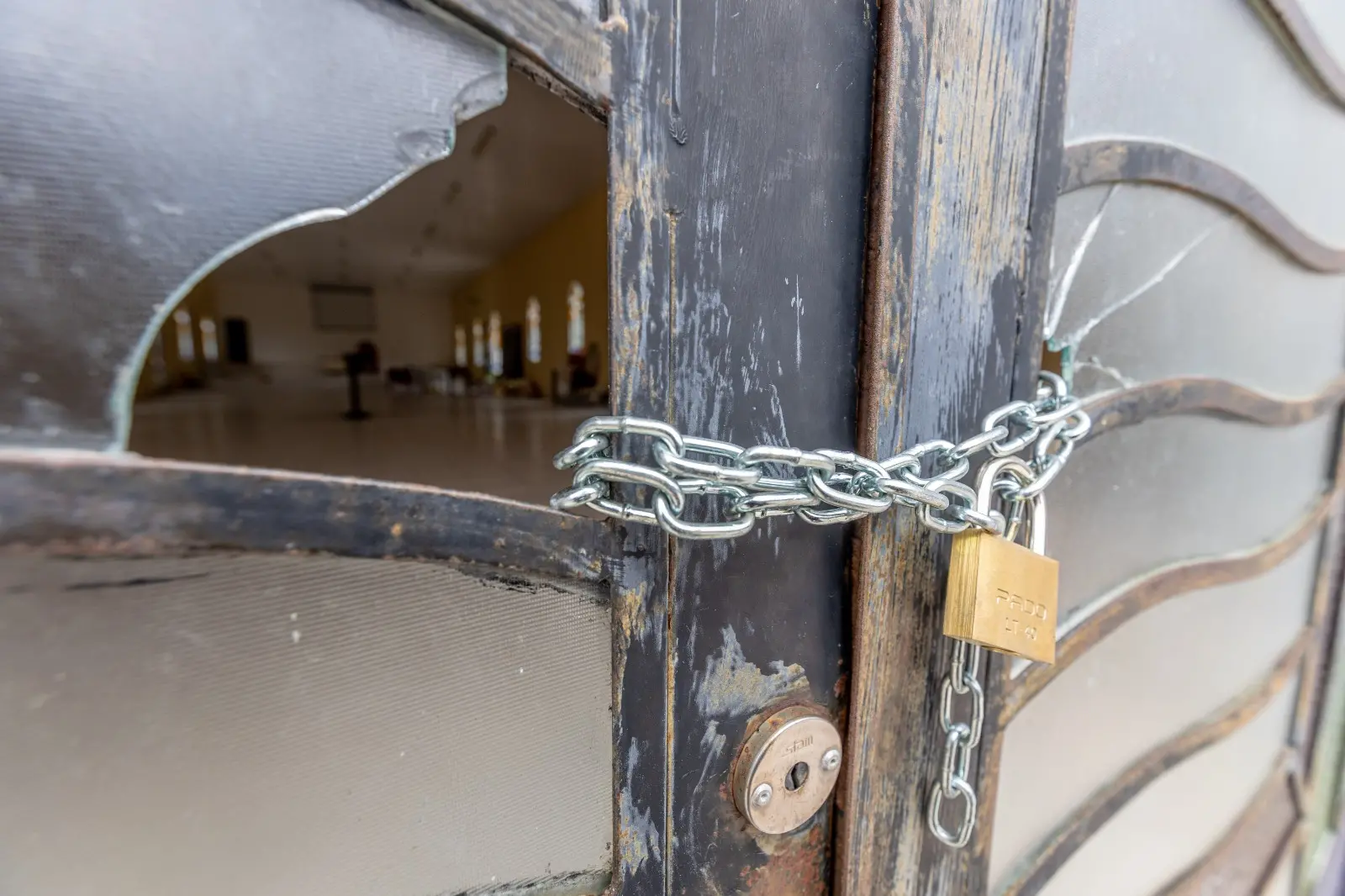 Foto detalhe de cadeado com correntes na porta de entrada de igreja