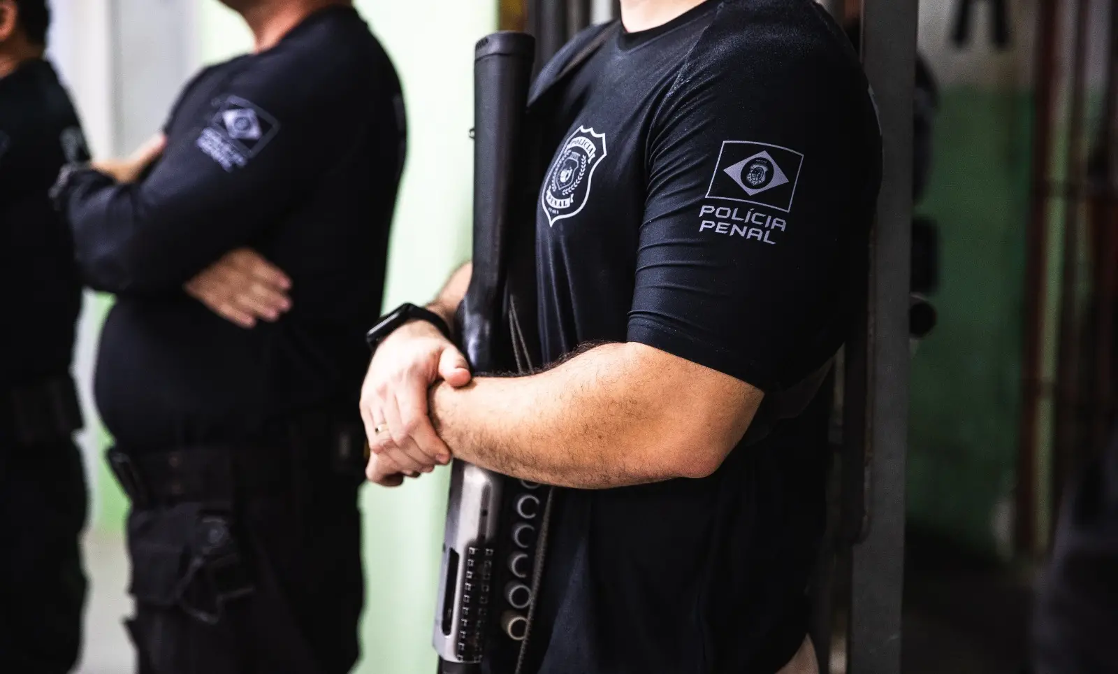 Foto de dois policiais penais do Ceará, uniformizados e armados em presídio cearense