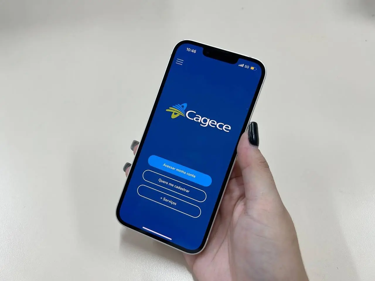 Mão feminina segura celular aberto no aplicativo da Cagece. Imagem usada em matéria sobre falta de água e direito do consumidor