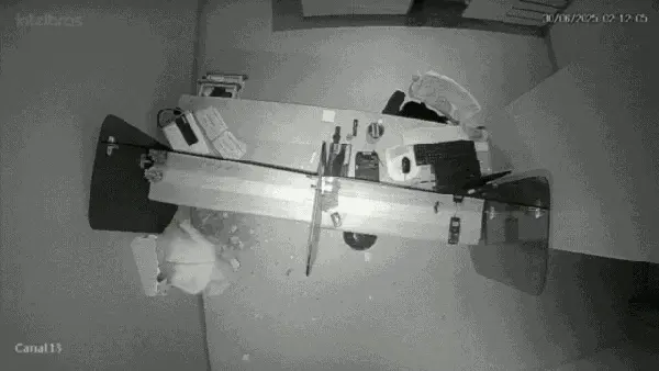 Captura de tela que mostra homem encapuzando quebrando muro de casa e invade banco ao lado