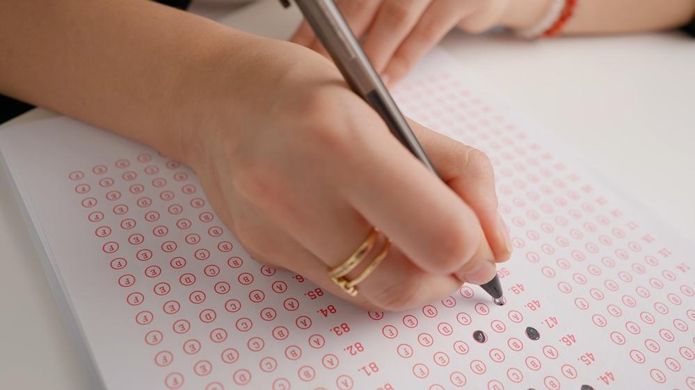 Foto de candidato preenchendo gabarito de prova. Imagem ilustrando matéria sobre inscrições abertas para o CNU e as novidades do concurso
