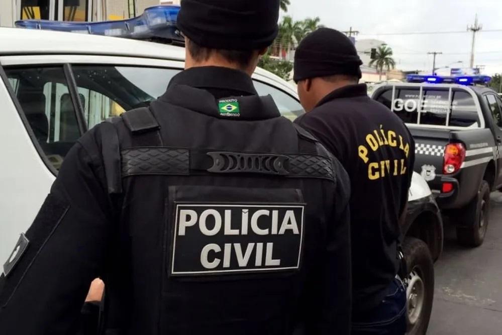 Agentes da Polícia Civil do Mato Grosso entrando em uma viatura. Em Mato Grosso, namorada de jovem que matou pais e irmão no RJ também planejava matar família