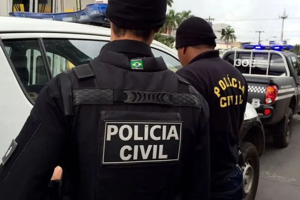 Agentes da Polícia Civil do Mato Grosso entrando em uma viatura. Em Mato Grosso, namorada de jovem que matou pais e irmão no RJ também planejava matar família