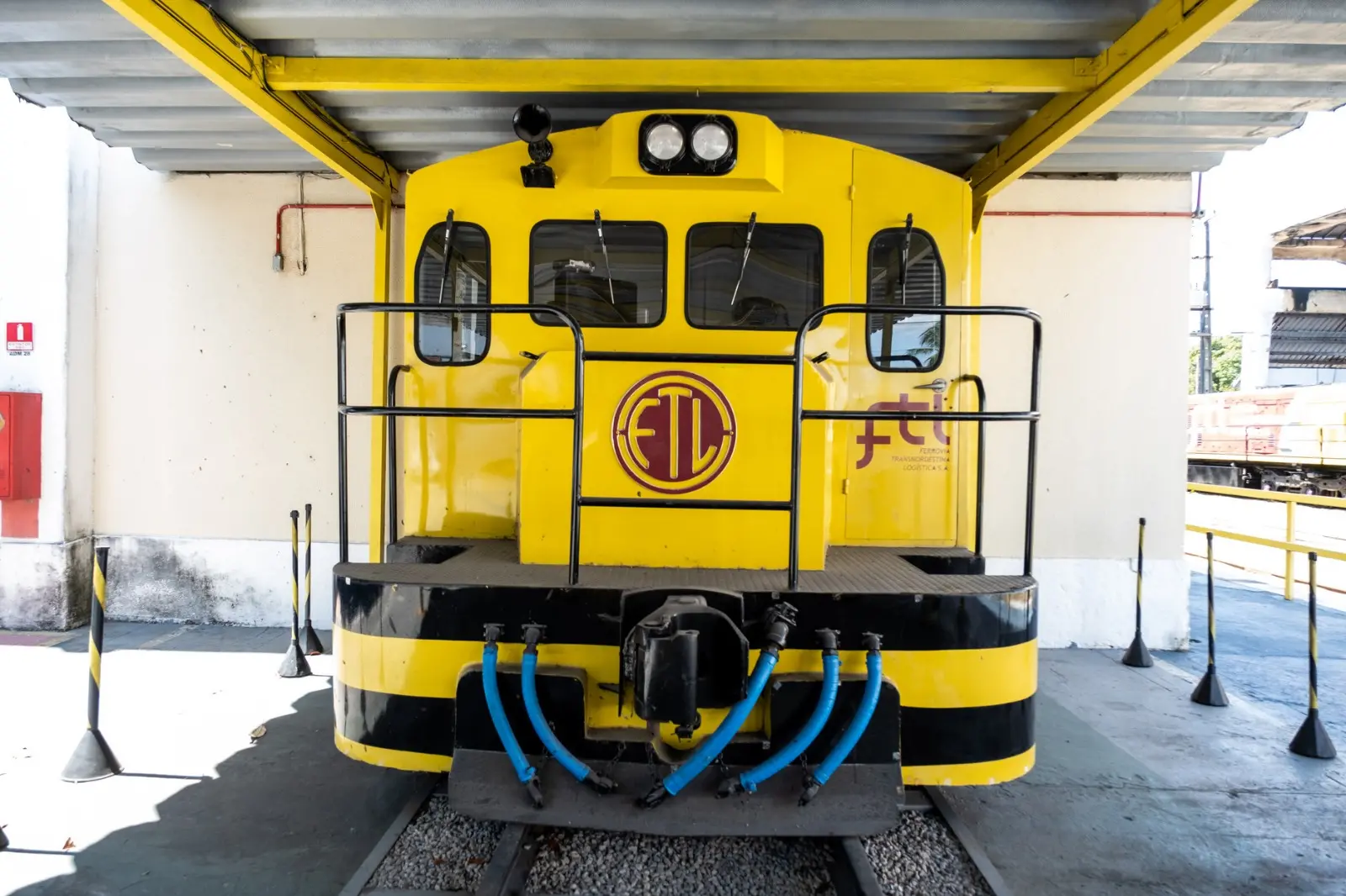 Foto que contém locomotiva antiga da FTL, nas cores amarela e grená