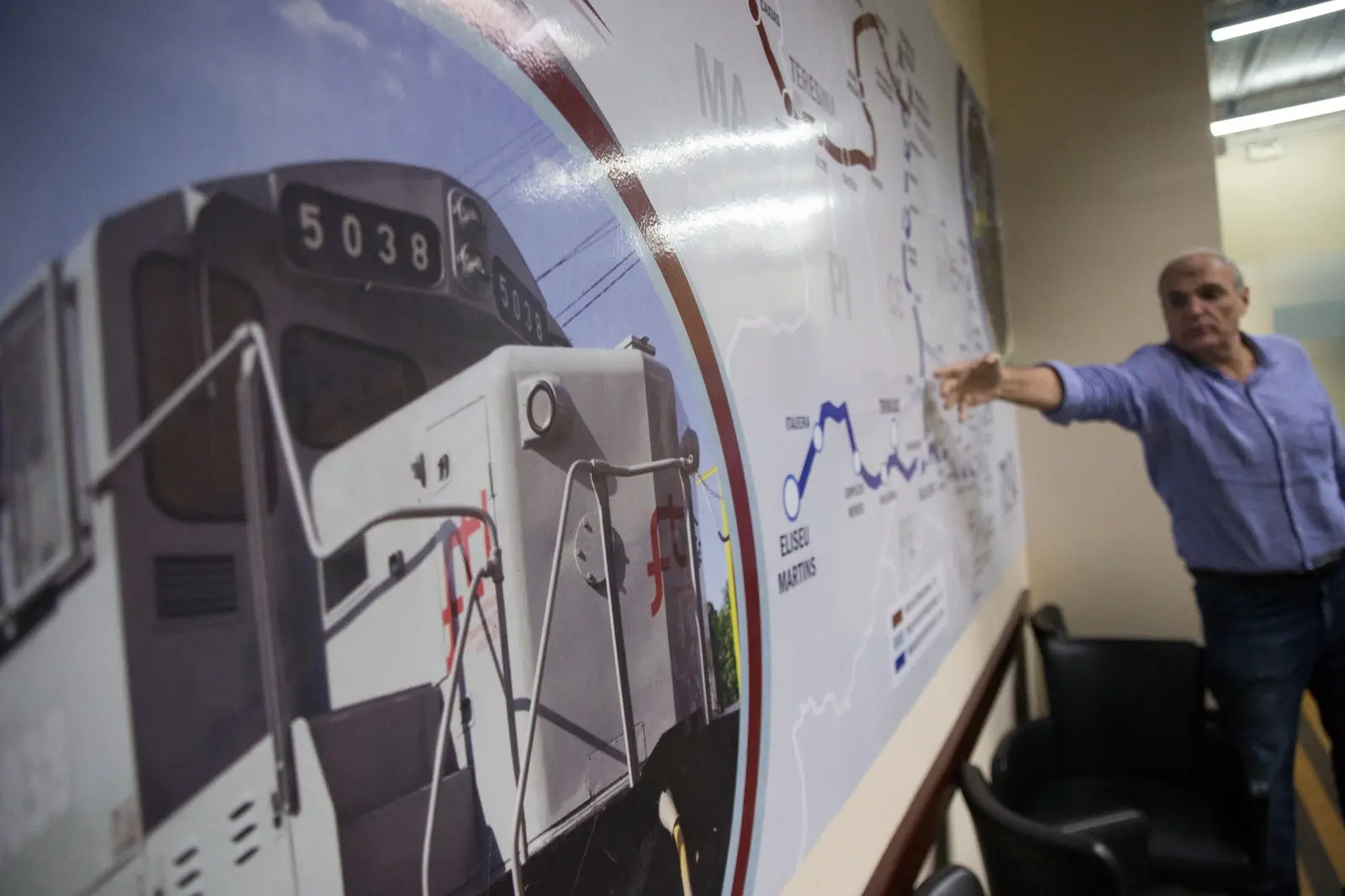 Foto que contém mapa da FTL com explicação de Tufi Daher Filho sobre traçado da ferrovia