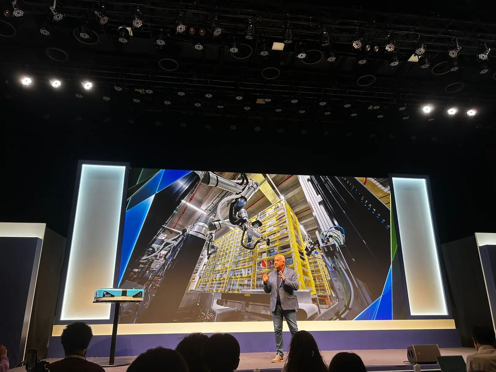 Imagem mostra homem em um palco, possivelmente falando ao público