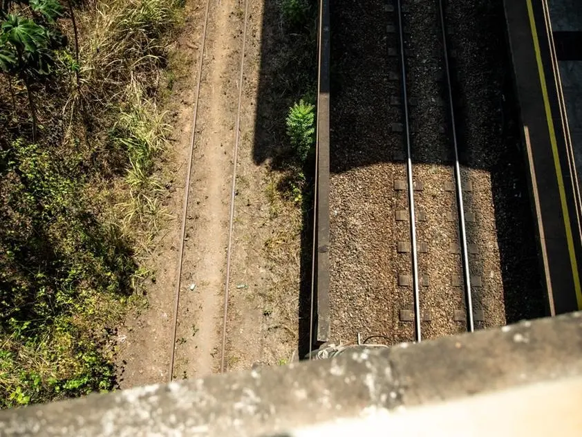 Foto que contém duas linhas férreas. Ao lado esquerdo, ela encontra-se abandonada e sem uso; do lado direito, revitalizada e com uso quase que diário