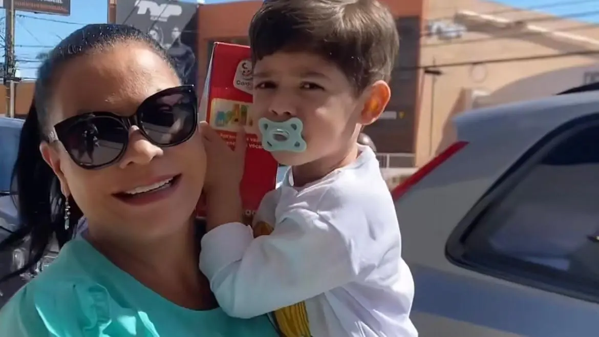Dona Ruth com Léo nos braços. Ele está de chupeta e segura um brinquedo. Imagem usada em matéria sobre decisão que garantiu a guarda provisória da criança ao pai Murilo Huff