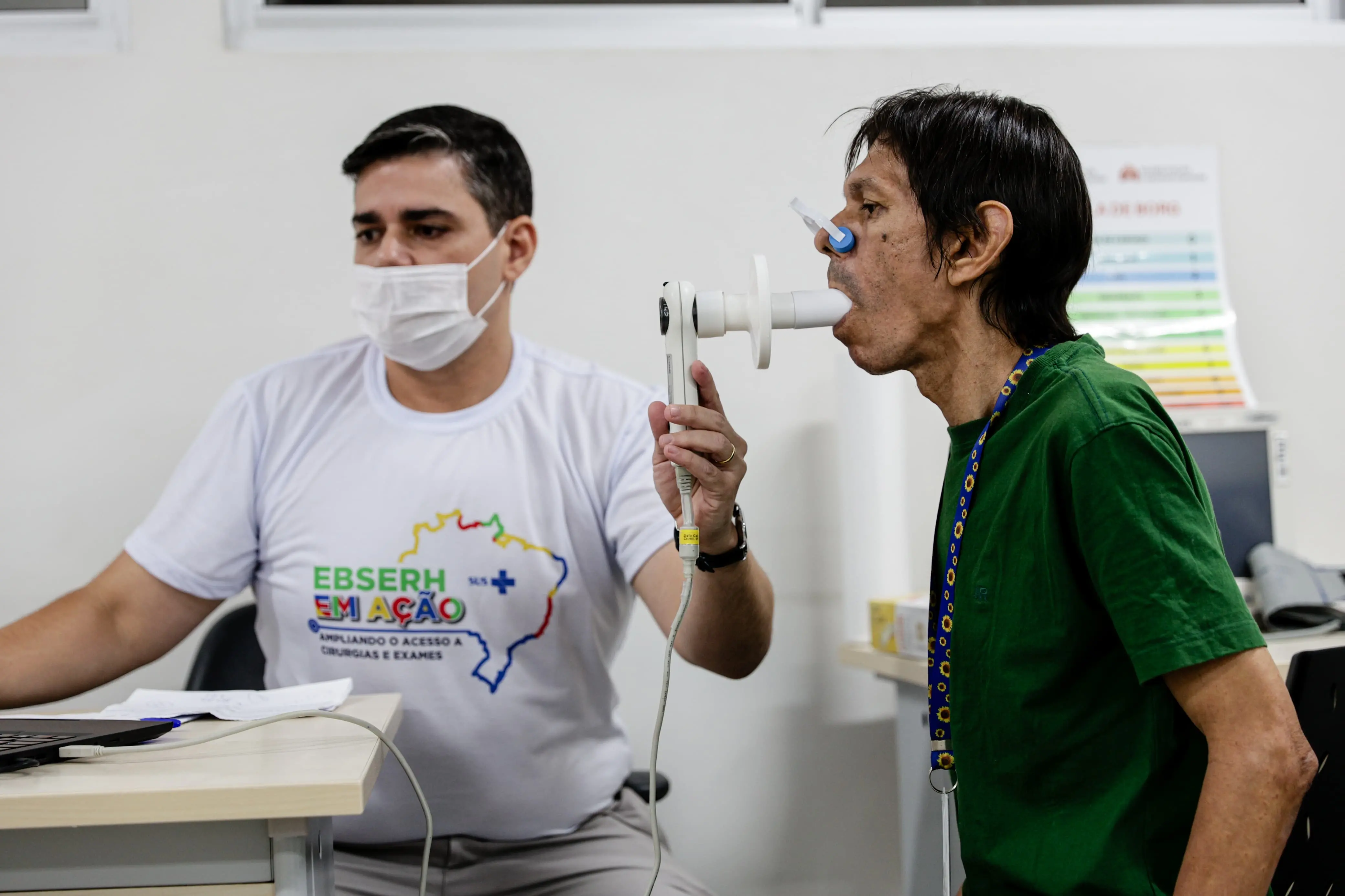 Foto que contém médico realizando exame por via oral em paciente em ambiente hospitalar