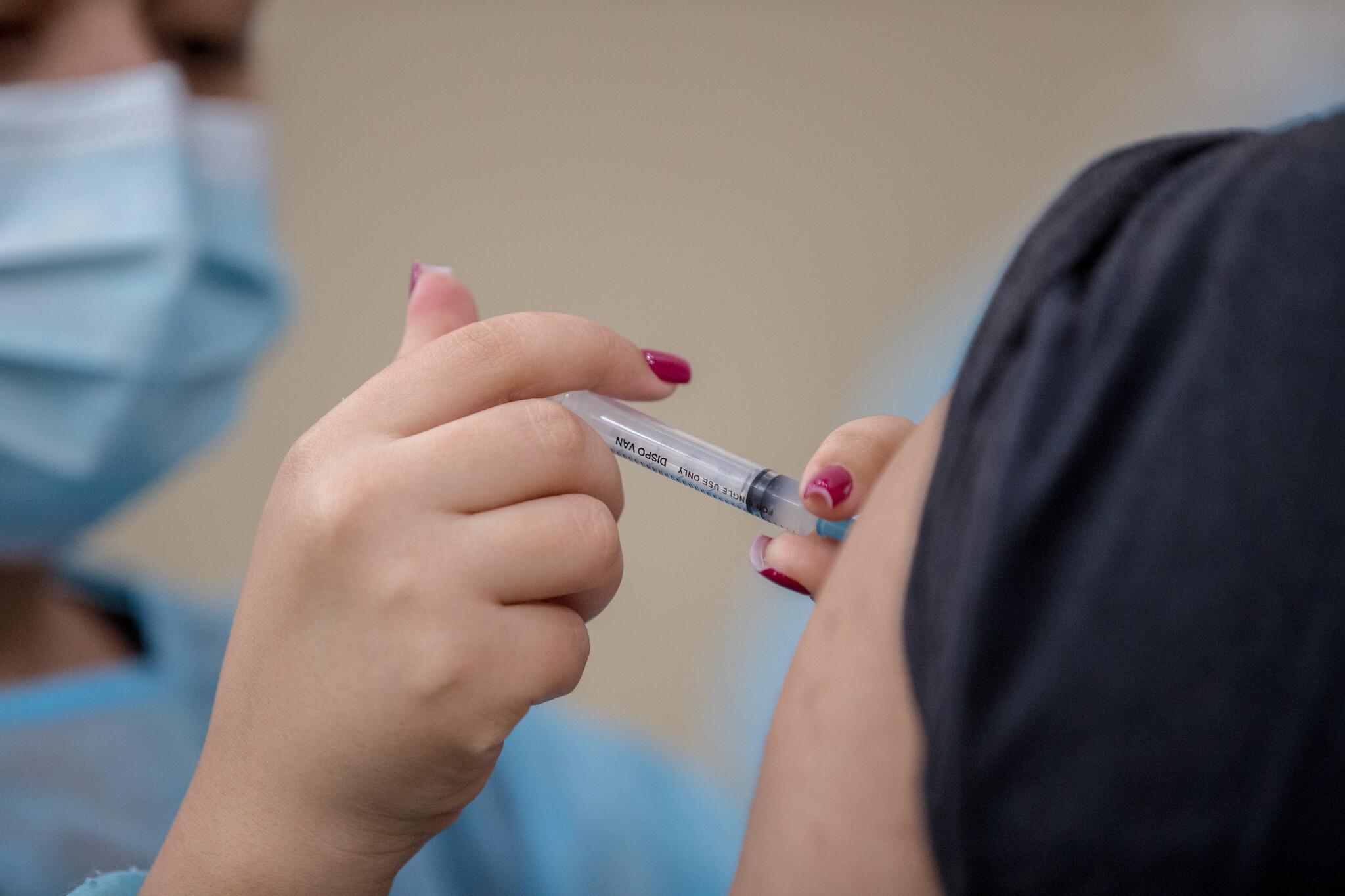 Enfermeira aplica vacina em paciente