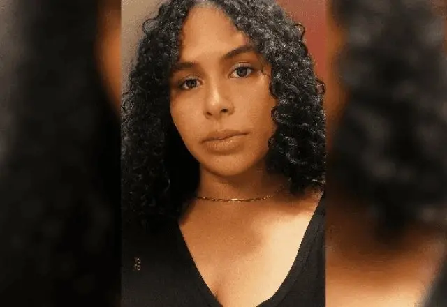 Selfie de Carmen. Uma mulher trans de cabelos cacheados pretos