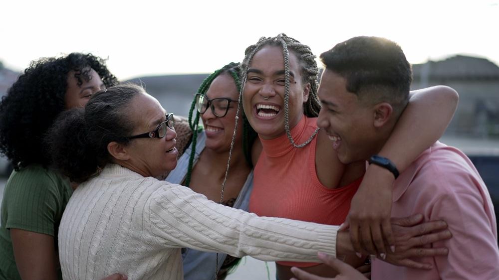 Na imagem, grupo de amigos se abraça durante encontro