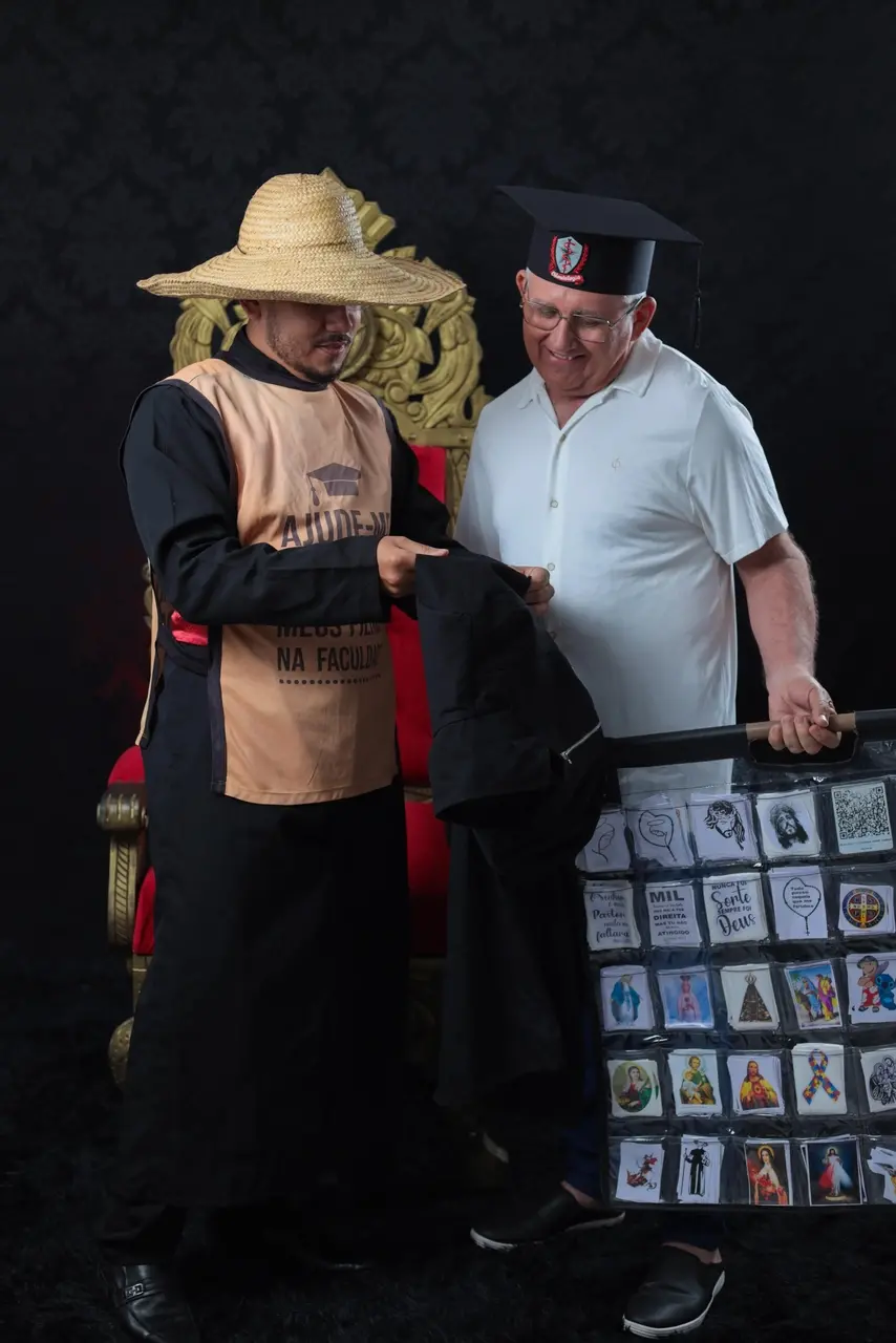 Matheus mostra o bordado do carrinho e do colete, em seu jaleco, para o pai Francisco da Merenda