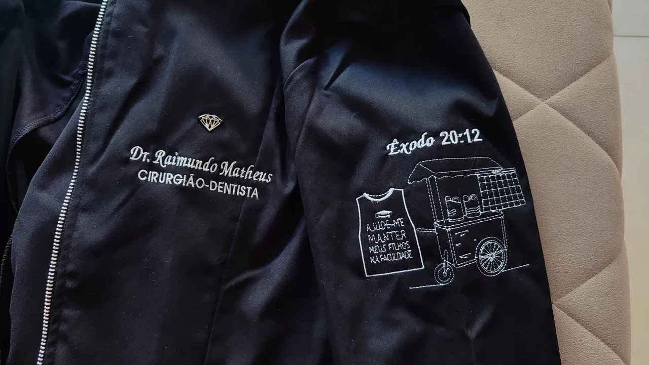 Matheus bordou na manga do jaleco o carrinho de lanches e o colete e catálogo de venda de adesivos do pai