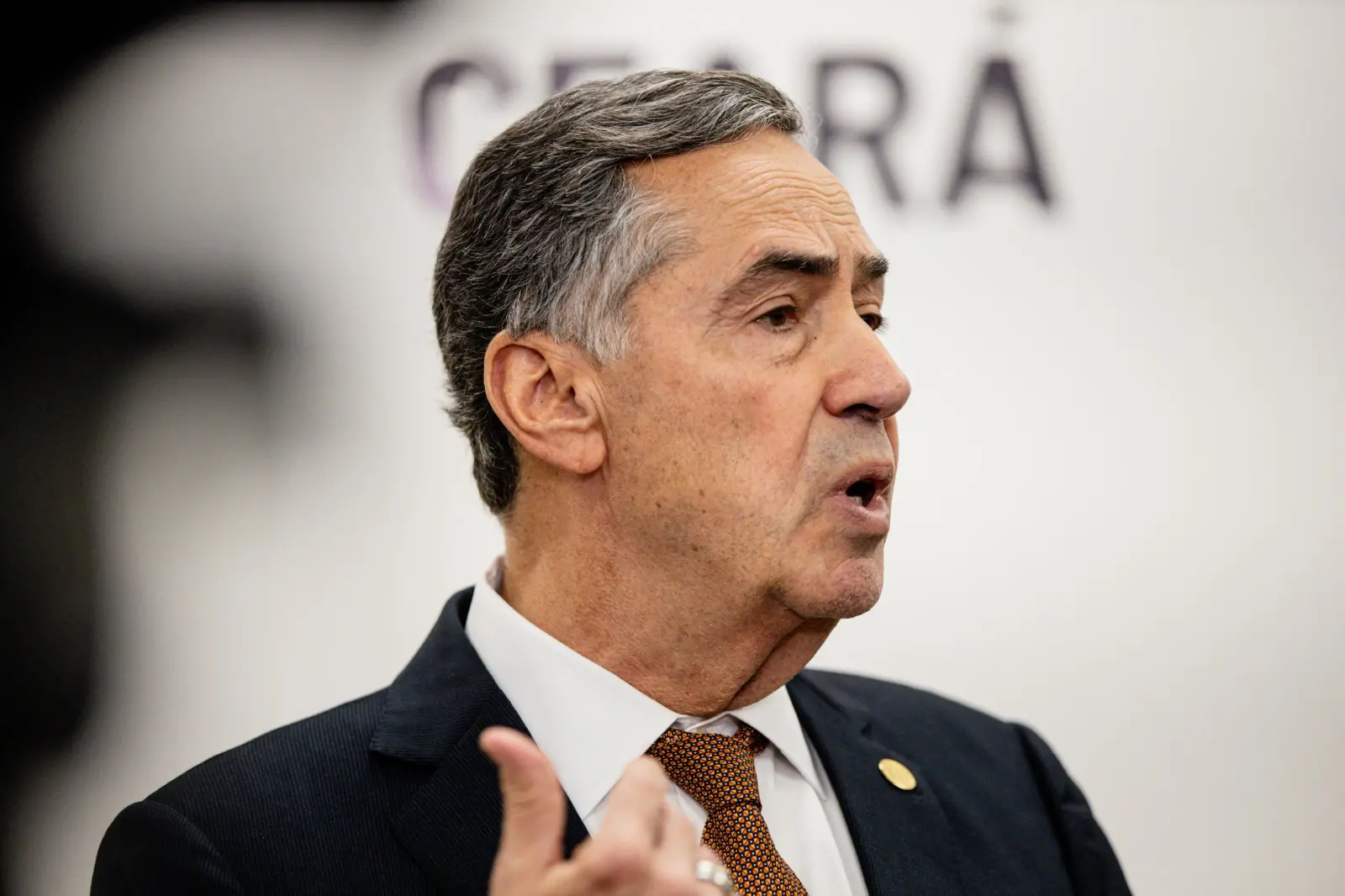 Imagem do presidente do STF na sede da OAB, com um fundo branco e a palavra 