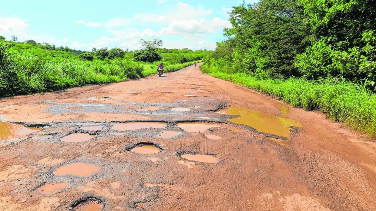 Foto que contém rodovia esburacada e com lama no interior do Ceará