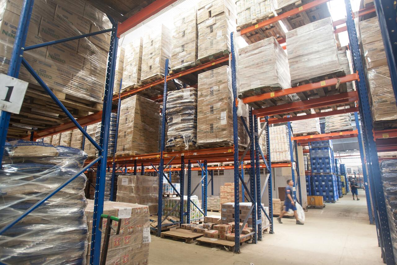 Galpão de estoque de supermercado com dezenas de caixas de papelão até o teto