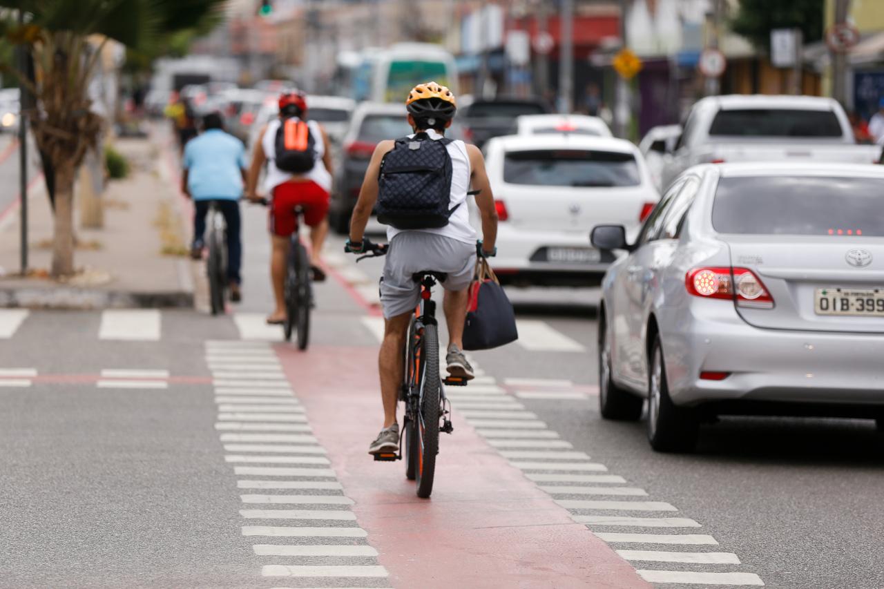 Ciclofaixa de avenida de Fortaleza com alguns ciclistas e carros ao lado