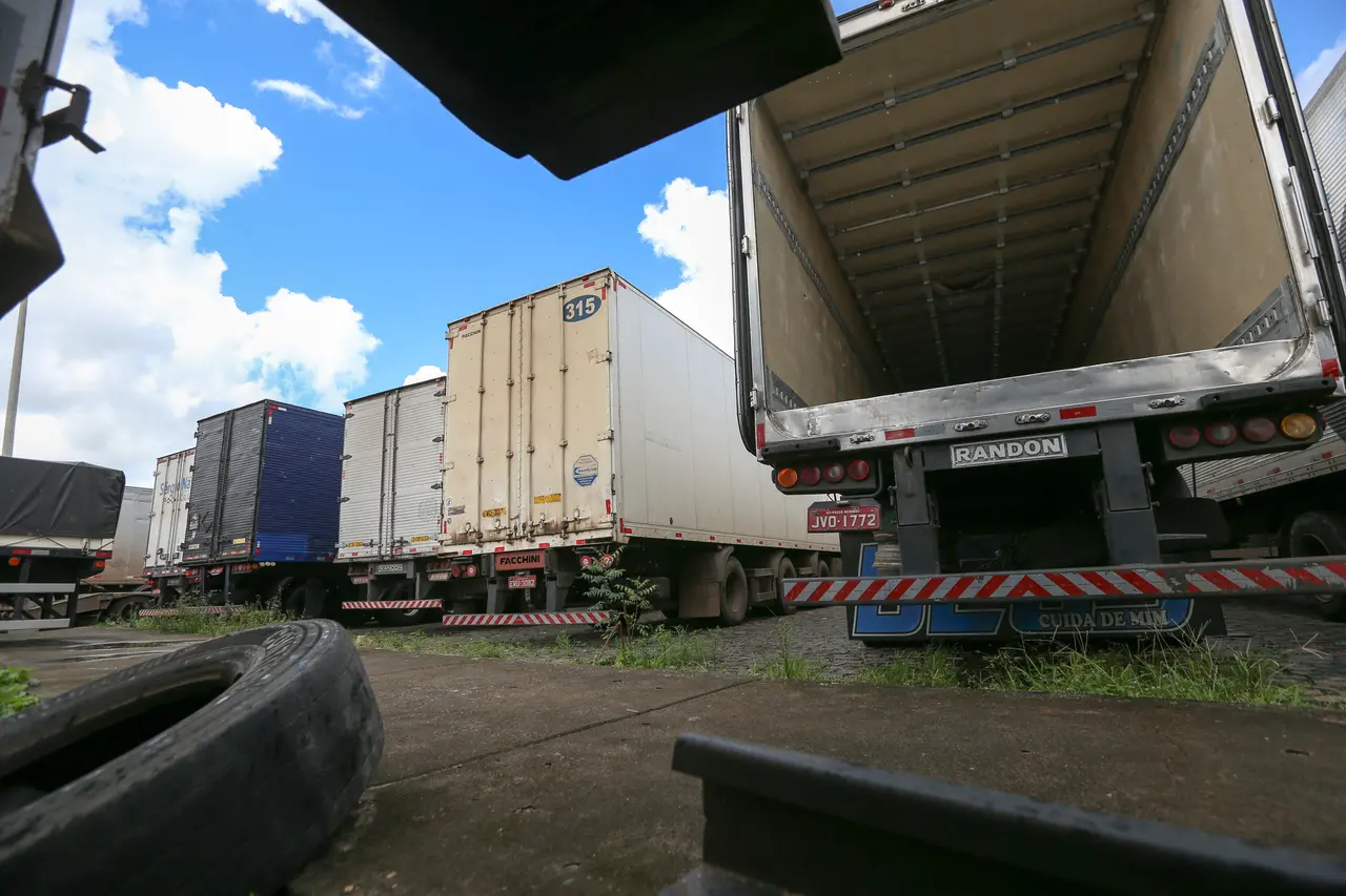 Caminhões baú com traseira aberta em oficina mecânica