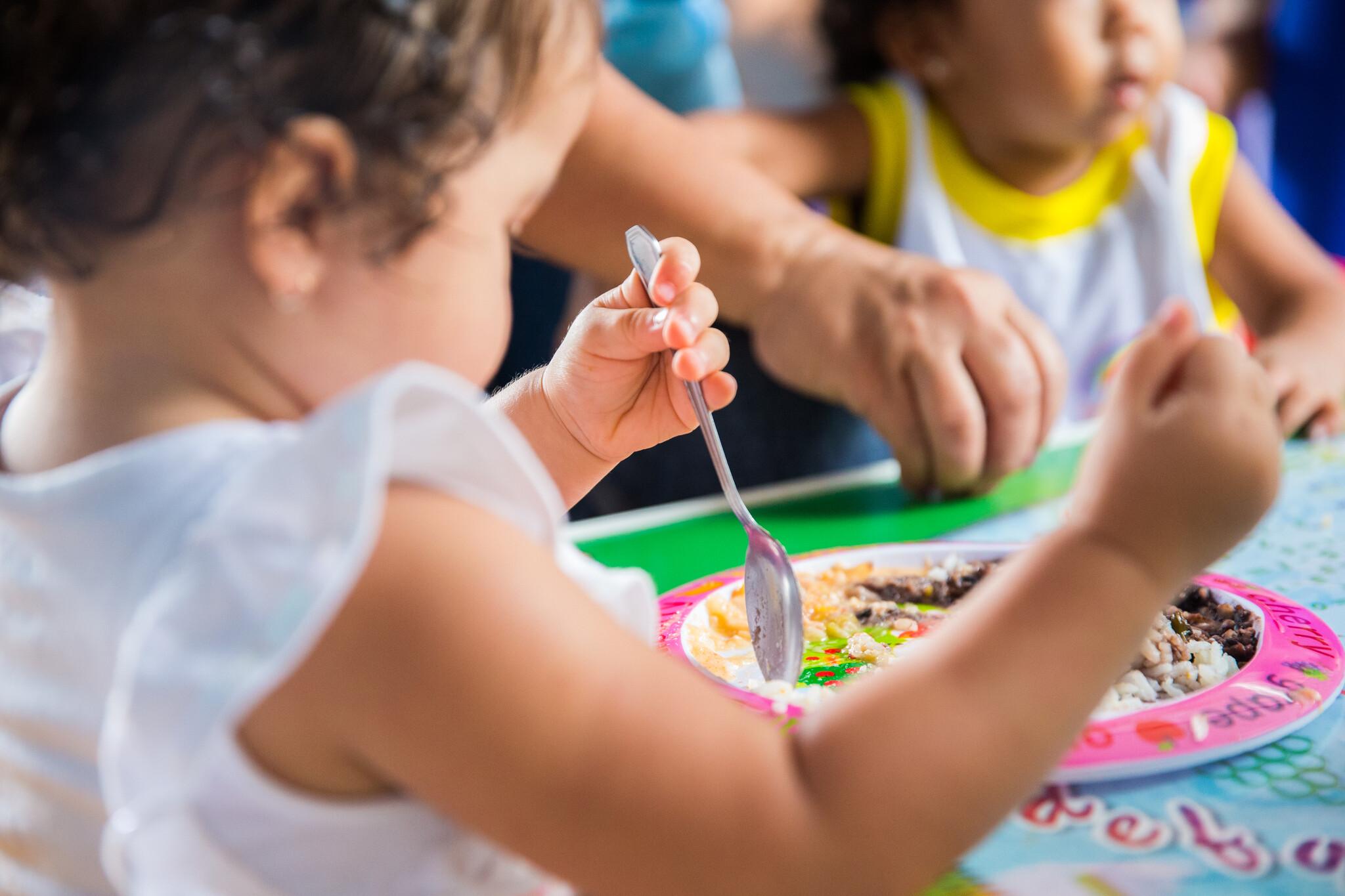 Menina pequena comendo em creche