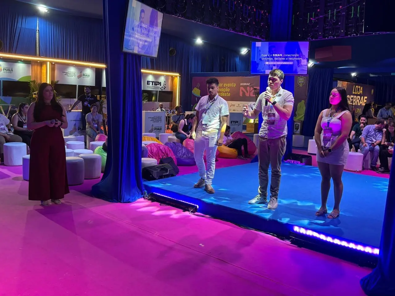 Os estudantes Guilherme Barros, Marcos Antônio e Maria Eduarda no evento NEON 2025