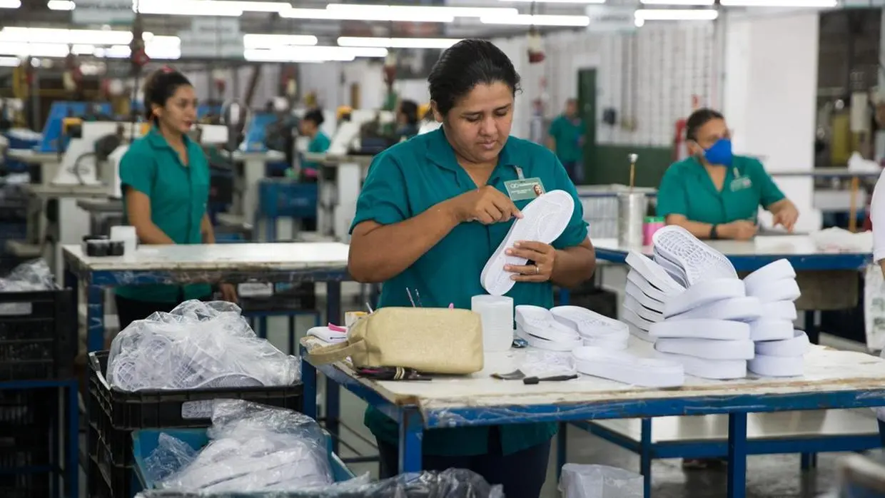 Mulher em fábrica de sola de sapato