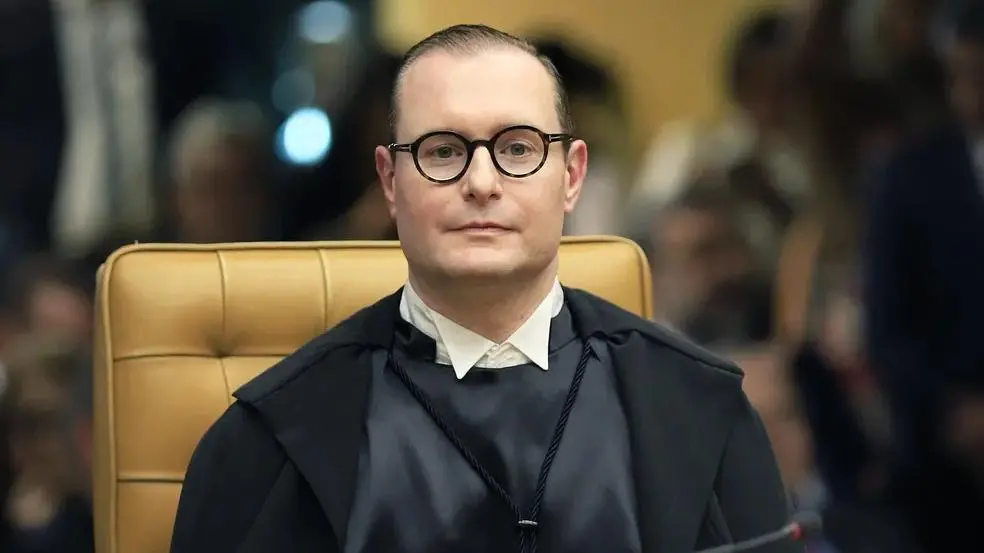 Foto do ministro do Supremo Tribunal Federal (STF) Cristiano Zanin. Ele utiliza toga preta e óculos