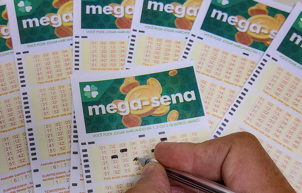 Pessoa preenchendo números da Mega-Sena no volante de aposta