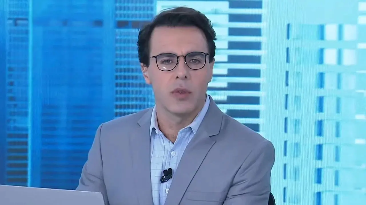 Rafael Colombo apresentando jornal em um fundo azulado