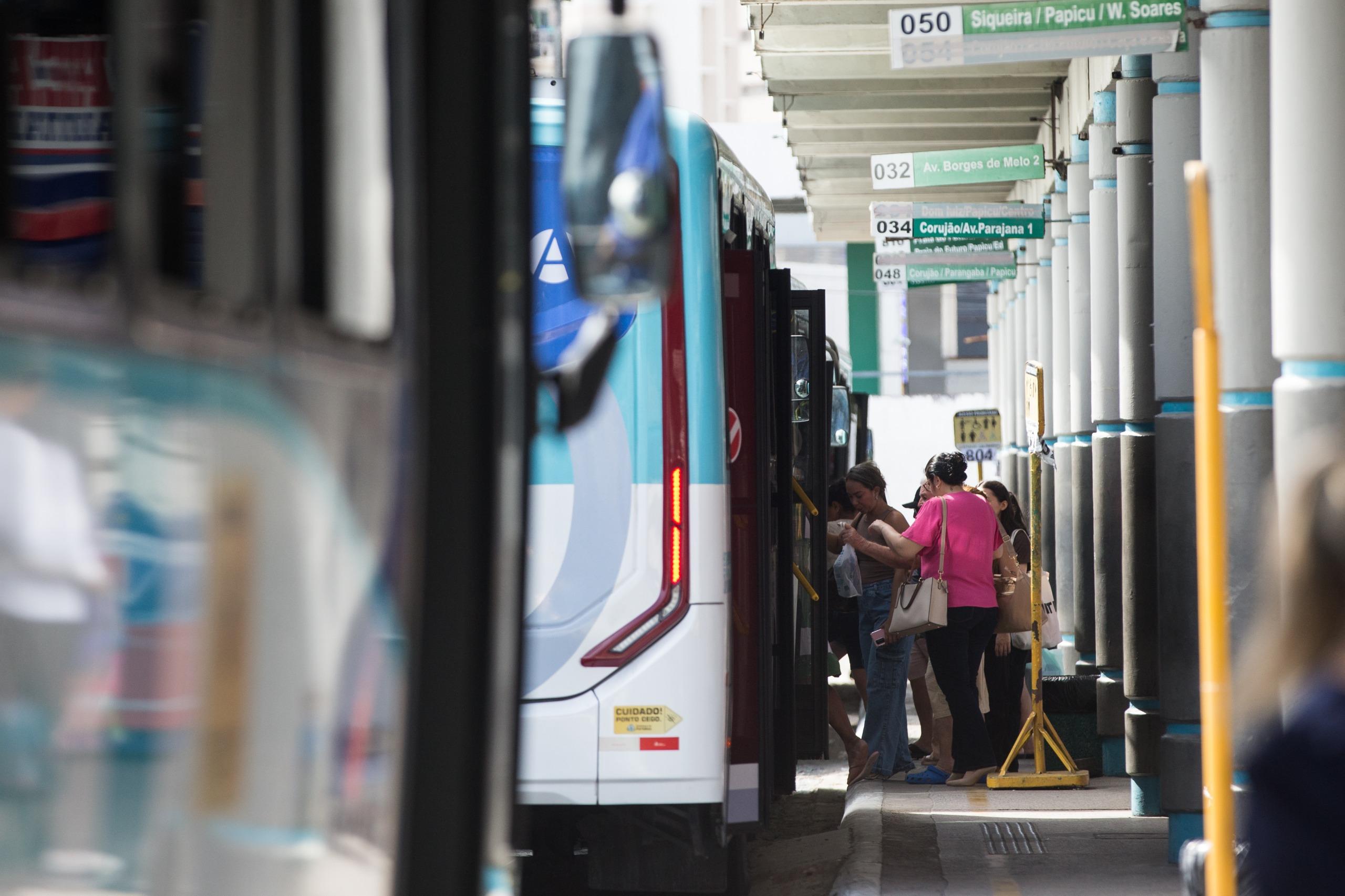 Imagem mostra fileira de ônibus no Terminal do Papicu, em Fortaleza. Ao fundo, passageiros se aglomeram para embarcar no veículo.