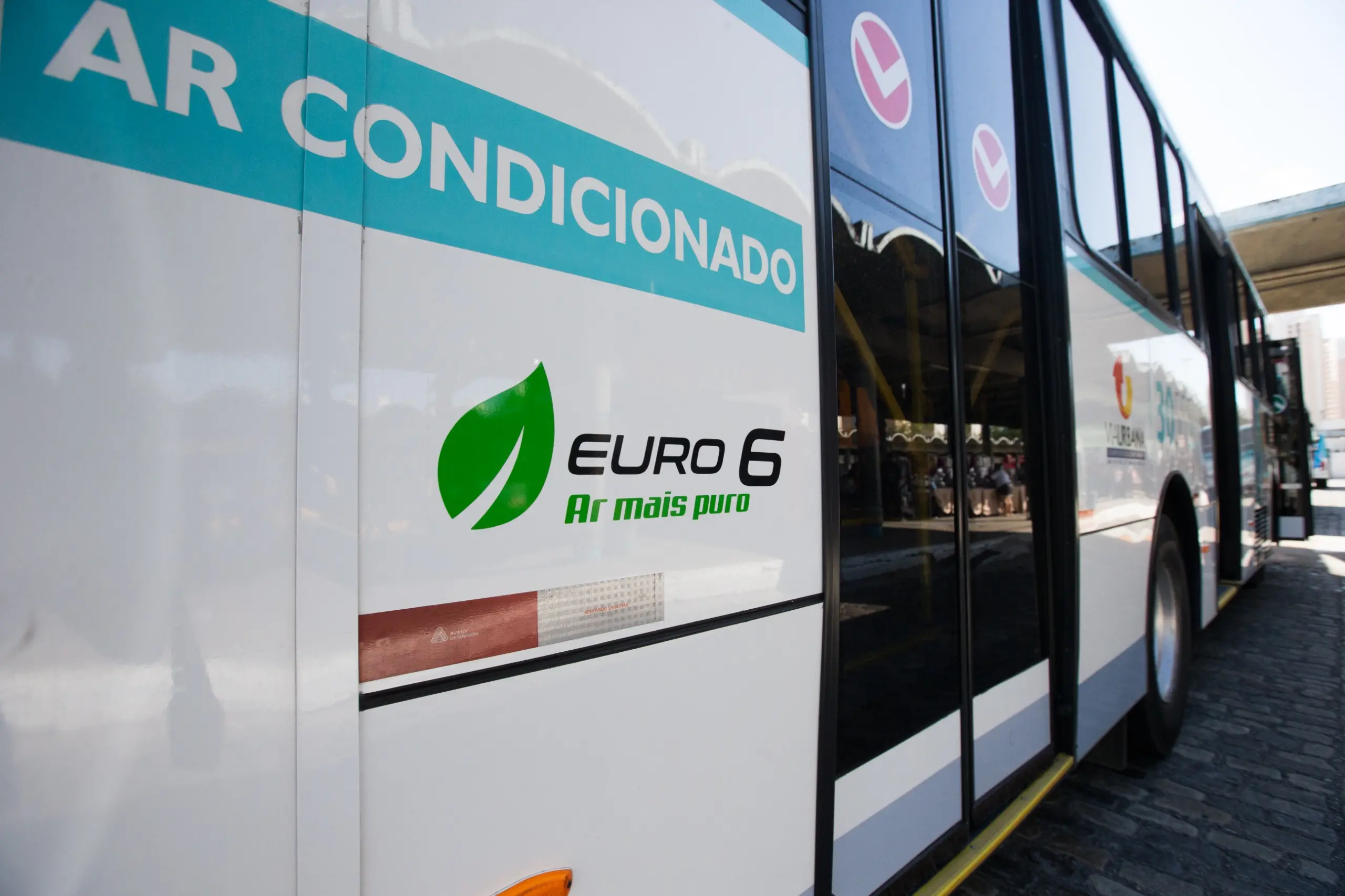 Imagem mostra traseira de ônibus da geração Euro 6, geração de veículos que polui menos. Na foto aparece o selo Euro 6, ar mais limpo.