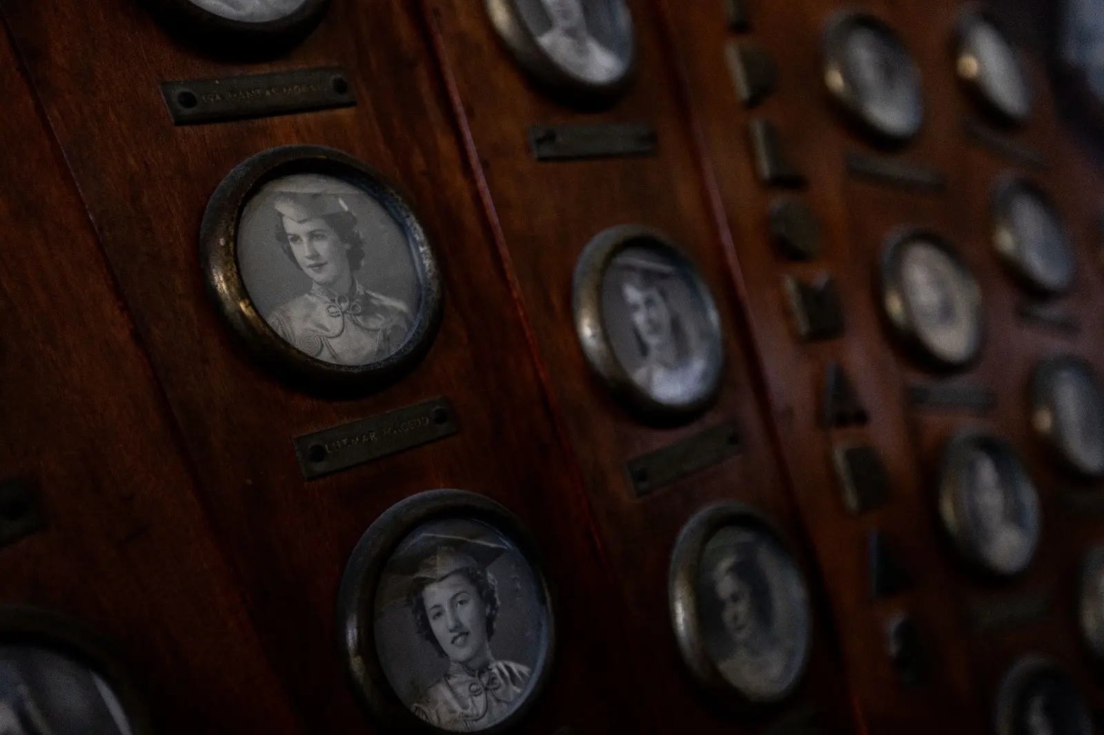 Imagem mostra placa de madeira com miniaturas de fotos de mulheres formadas no Colégio da Imaculada Conceição