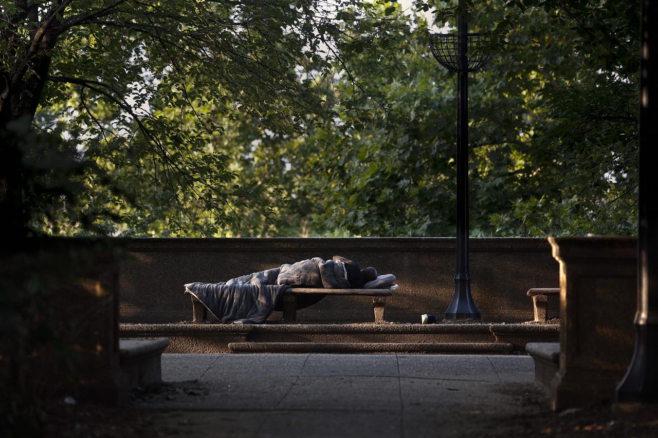 Imagem mostra pessoa em situação de rua dormindo em banco de praça em Washington, nos Estados Unidos, ilustrando fala de Trump que pediu às pessoas sem teto para deixar Washington.